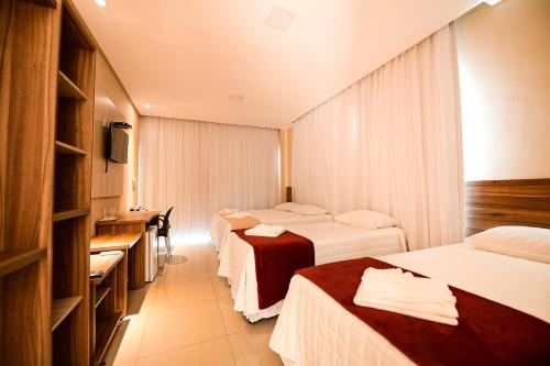 מיטה או מיטות בחדר ב-TRIUNFO PAPO HOTEL