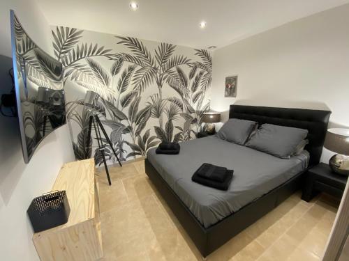 ein Schlafzimmer mit einem Bett und einem Wandbild in der Unterkunft Bord de mer la Ciotat in La Ciotat