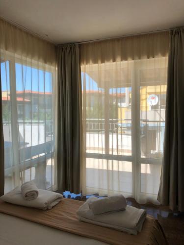 a bedroom with a window with towels on a bed at Family Hotel Littoral in Sozopol