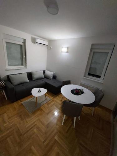 a living room with a couch and a table at Vrnjačka Banja Apartman in Vrnjačka Banja