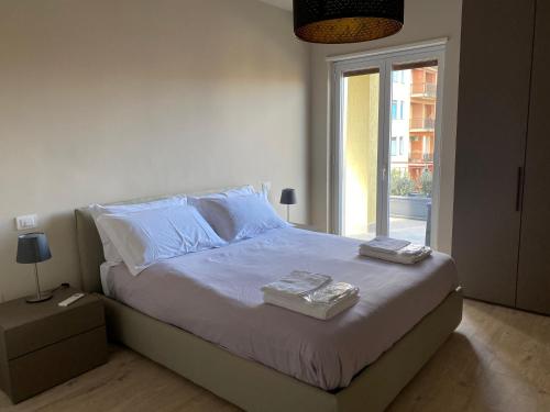 Un dormitorio con una cama con sábanas blancas y una ventana. en ViCo HomeSuite, en Milazzo