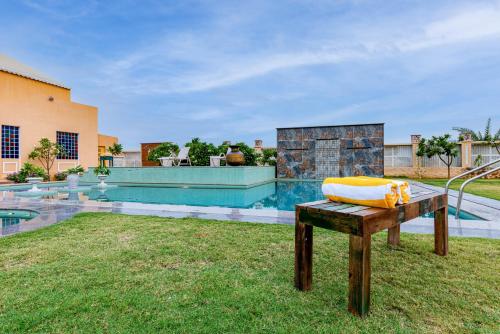 a bench in the yard of a house with a pool at Anand Bagh Resort & Spa by Ananta in Sālāsar