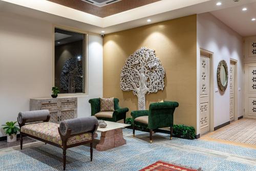 a waiting room with green chairs and a table at Anand Bagh Resort & Spa by Ananta in Sālāsar