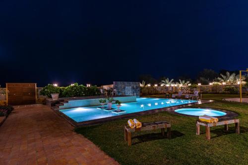 a swimming pool at night with lights at Anand Bagh Resort & Spa by Ananta in Sālāsar