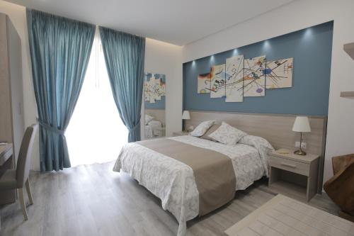 ein Schlafzimmer mit einem Bett und einer blauen Wand in der Unterkunft B&B La Stazione in Diamante