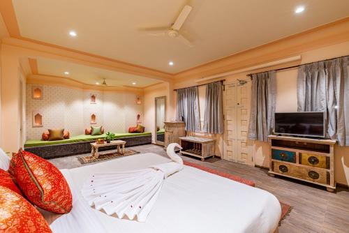 a bedroom with a large bed and a television at Anand Bagh Resort & Spa by Ananta in Sālāsar