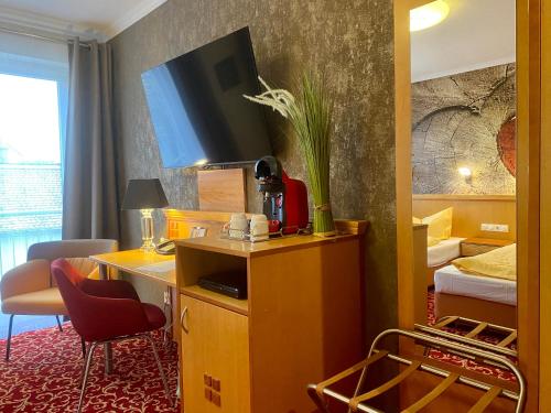 a hotel room with a tv on top of a desk at Querfurter Hof in Querfurt