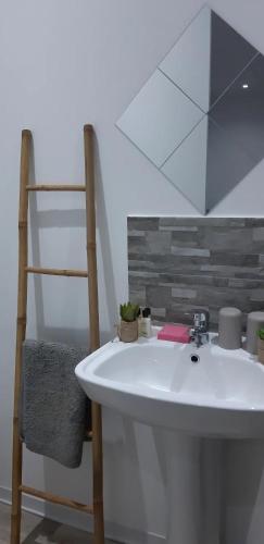 a bathroom with a white sink and a chair at Bungalow Harmony in Baie Mahault