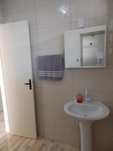 y baño con lavabo blanco y espejo. en Kitnet calma, en São José