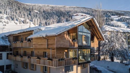 a log cabin with snow on the roof at Apartments Bachmann in San Candido