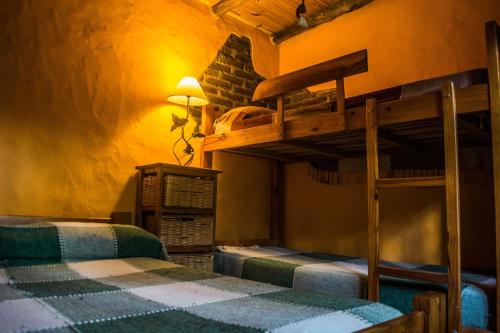 a bedroom with two bunk beds in a room at Giramundo Hostel y Posada Eco-Cultural in San Marcos Sierras