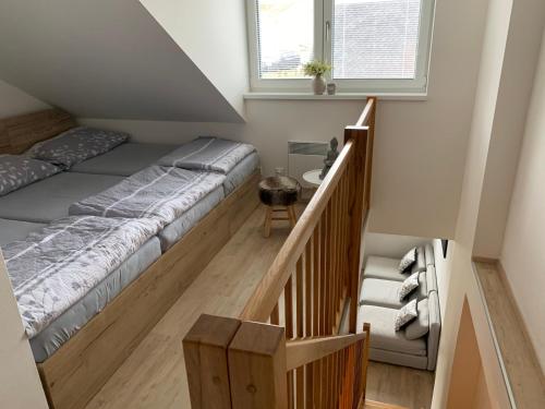 a bedroom with a large bed and a staircase at Sport Apartmán DM in Dolní Morava