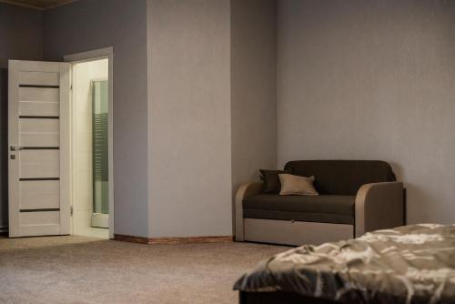 a bedroom with a bed and a couch and a door at Bratkivchanka in Yablunytsya