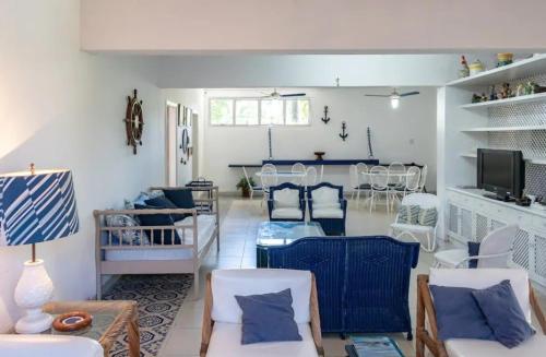 ein Wohnzimmer mit blauen und weißen Möbeln in der Unterkunft Casa com seis suites, Praia de Pernambuco Guarujá in Guarujá