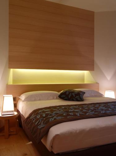 a bedroom with a bed with a headboard and lights at Hotel Natura in Castel di Sangro