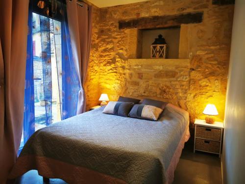 ein Schlafzimmer mit einem Bett und einer Steinmauer in der Unterkunft Gîte Les Combes Montignac Lascaux in Montignac