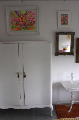 a white cabinet in a room with a table at Allegra Dalila Casa Hotel-Arte in Tandil