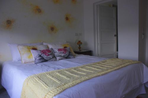 a bedroom with a bed with white sheets and pillows at Allegra Dalila Casa Hotel-Arte in Tandil