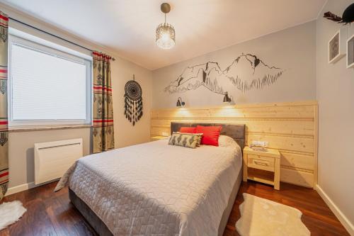 a bedroom with a bed and a mountain mural on the wall at Apartament Siwy Wierch in Kościelisko