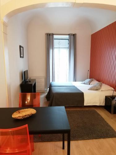 a bedroom with a bed and a table and a window at Evora Inn in Évora