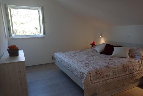 a bedroom with a bed and a window at Apartment Lucija with sea view in Dubrovnik