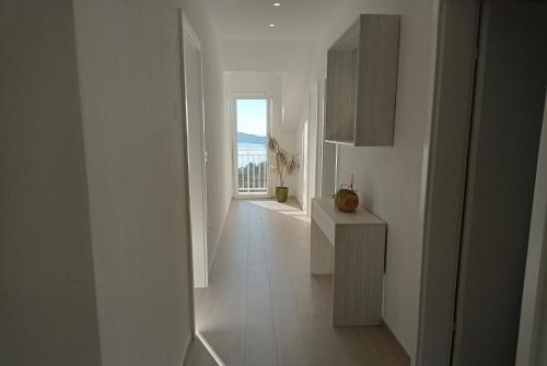 a hallway with a white room with a view of the ocean at Apartment Lucija with sea view in Dubrovnik
