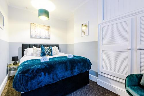 a bedroom with a bed with a blue blanket at Smart home near Chester City Centre in Chester