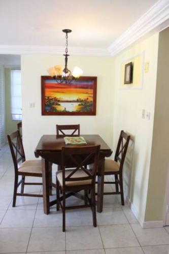 a dining room with a wooden table and chairs at Seacastles by the beach/pool in Montego Bay