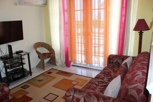 a living room with a couch and a flat screen tv at Seacastles by the beach/pool in Montego Bay