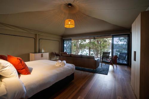 a bedroom with a large bed and a living room at Marramarra Lodge in Bar Point