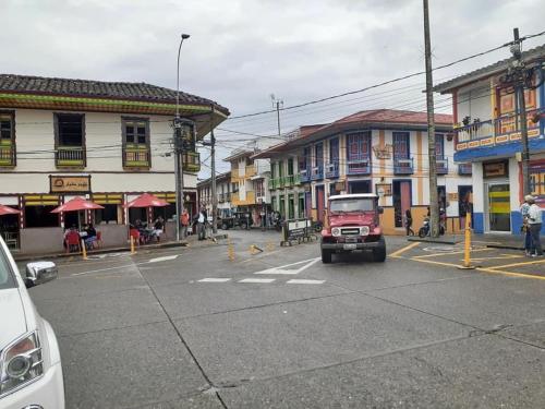 a red truck driving down a street in a town at Penthouse - Vista Hermosa Apartments in Filandia
