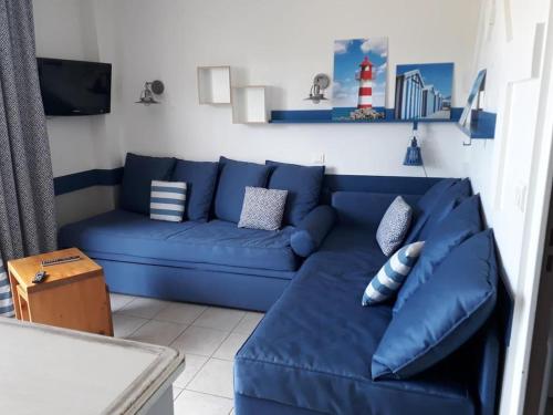 a blue couch in a living room at Villa 6 pers pierre et vacances Belle Dune in Fort-Mahon-Plage