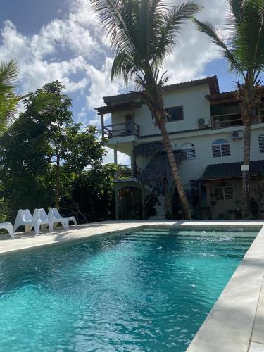 a house with a swimming pool in front of a house at Residencia El Balatà in Las Terrenas