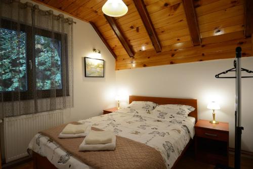 a bedroom with a bed with two towels on it at Apartmani Ogi i Ana in Bajina Bašta