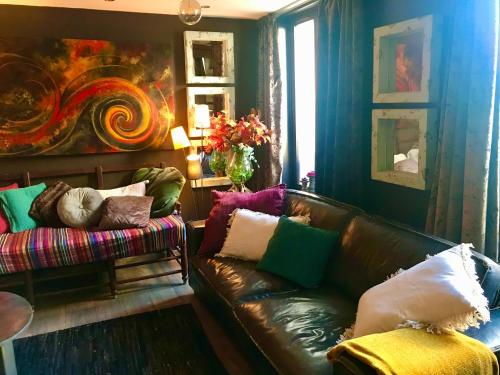 sala de estar con sofá de cuero y pintura en L’élégance au coeur du Médiéval, en Provins