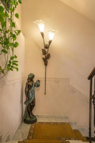 a lamp on the wall with a statue on the floor at Liberty Hotel in Catania