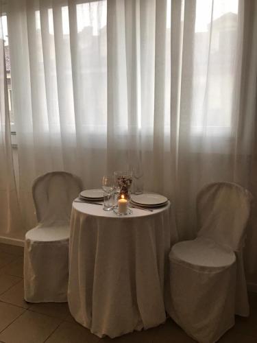 uma mesa com duas cadeiras e uma vela sobre ela em San Donato Apartment em Turim