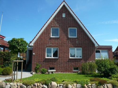 a brick house with a bench in front of it at Lust auf Meer - Ferienappartement in Cuxhaven