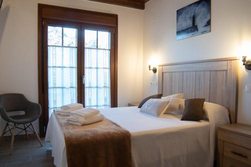 een slaapkamer met een groot bed en handdoeken bij Apartamentos Rurales Camín Real in La Caridad