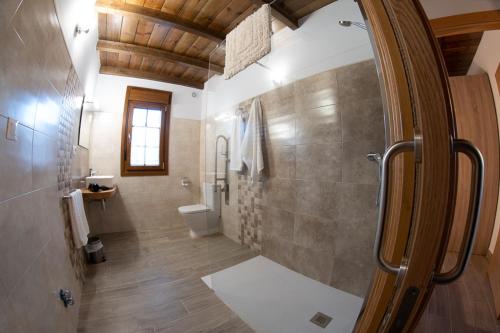 een badkamer met een douche en een toilet bij Apartamentos Rurales Camín Real in La Caridad