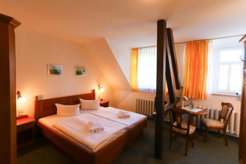 a hotel room with a bed and a table and chairs at Parkhotel Forsthaus in Tharandt