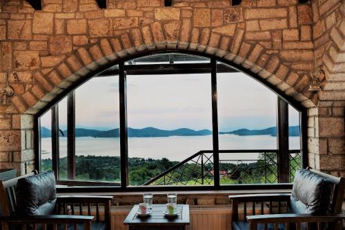 an arched window in a restaurant with a view of the water at Archontiko Zakoni in Neochori