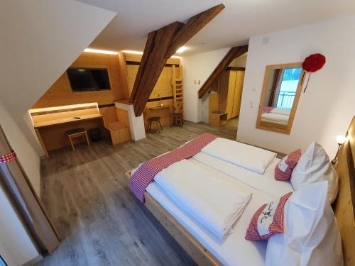 een slaapkamer met een groot bed en een bureau bij Gasthaus zum Hirschen in Furtwangen