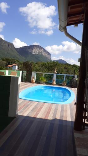 a large swimming pool on a patio with mountains in the background at Vyzuh in Vale do Capao