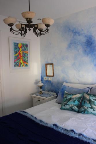 a bedroom with a bed with a painting on the wall at Allegra Dalila Casa Hotel-Arte in Tandil
