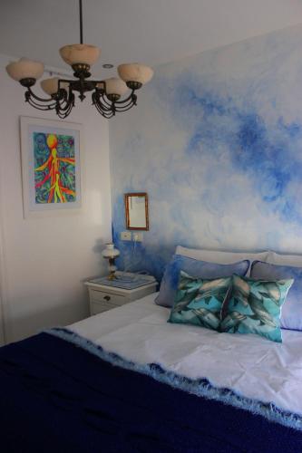 a bedroom with a blue painted wall with a bed at Allegra Dalila Casa Hotel-Arte in Tandil
