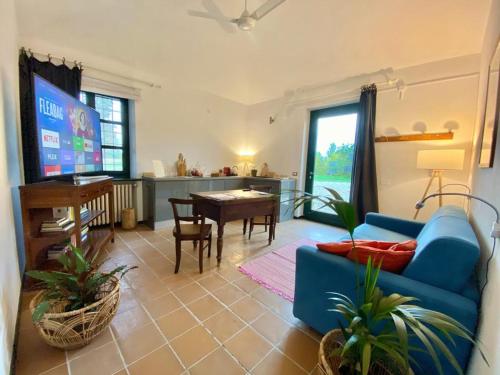 a living room with a blue couch and a tv at La Fornace in Alessandria