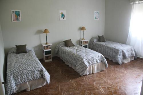 a bedroom with two beds and two night stands at Casa Club en el Náutico Timón in Luján