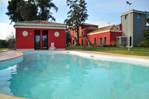 una piscina frente a una casa en Palazzo Rosso, en Riposto