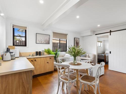 a kitchen and living room with a table and chairs at Watersedge in Currarong